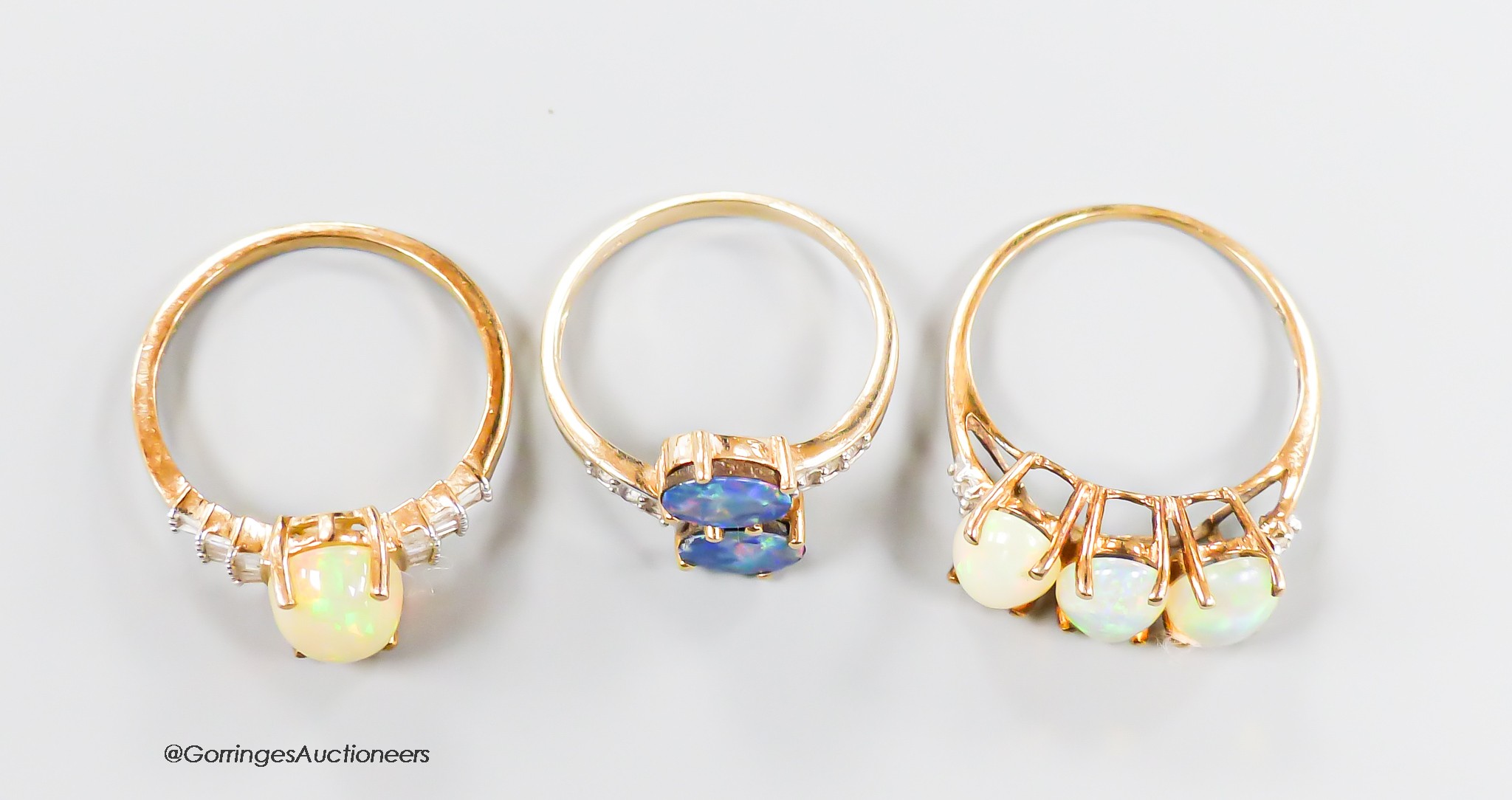 Two modern 9ct gold, opal and diamond set dress rings, size P & P/Q and one other 9ct gold and two stone opal doublet set dress ring, gross weight 6.8 grams.
